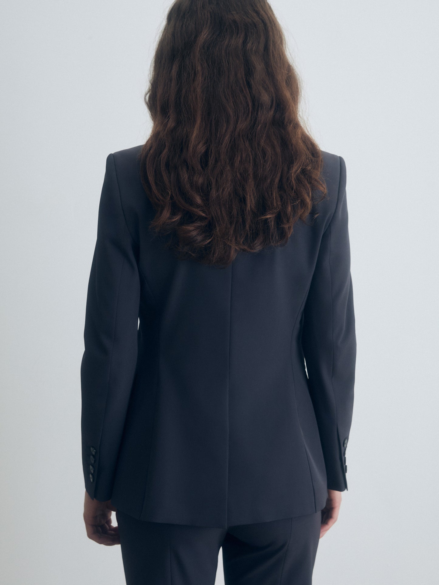 Person wearing a dark gray suit on a white background