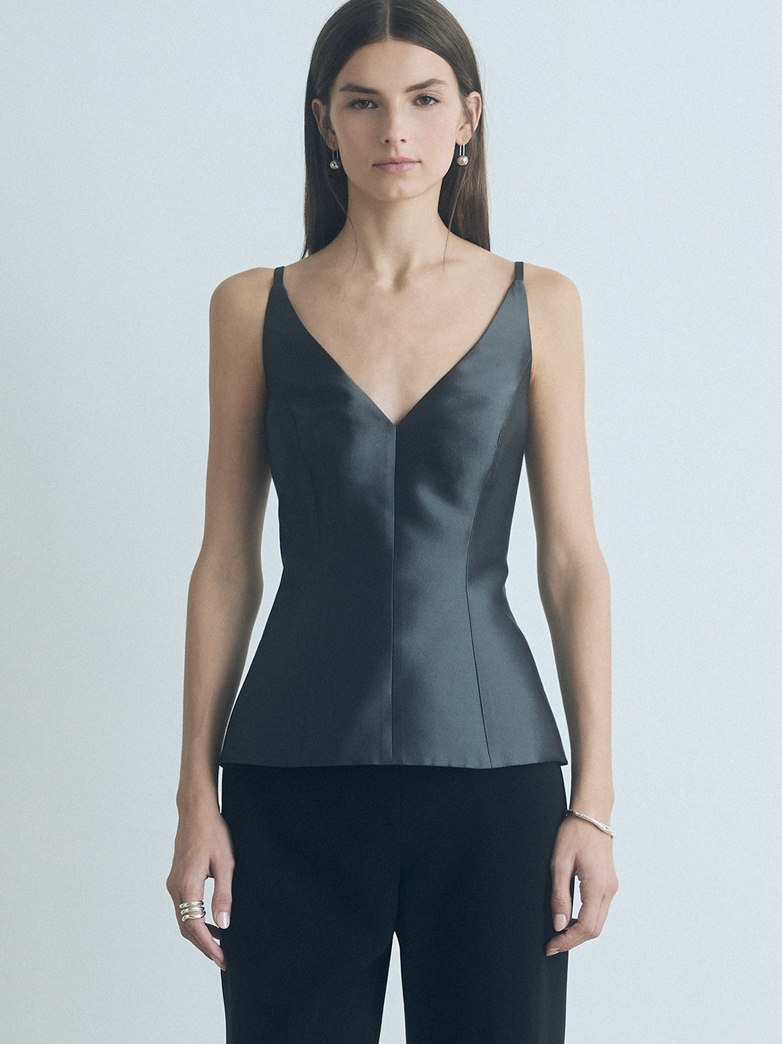 Woman wearing an anthracite judith and charles sleeveless top and black pants against a plain background