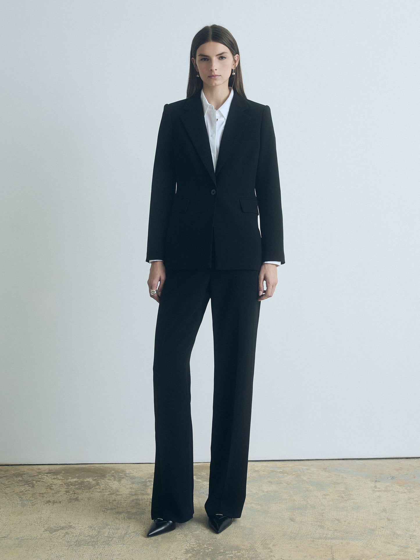 Model wearing a black judith and charles with a white shirt against a plain background