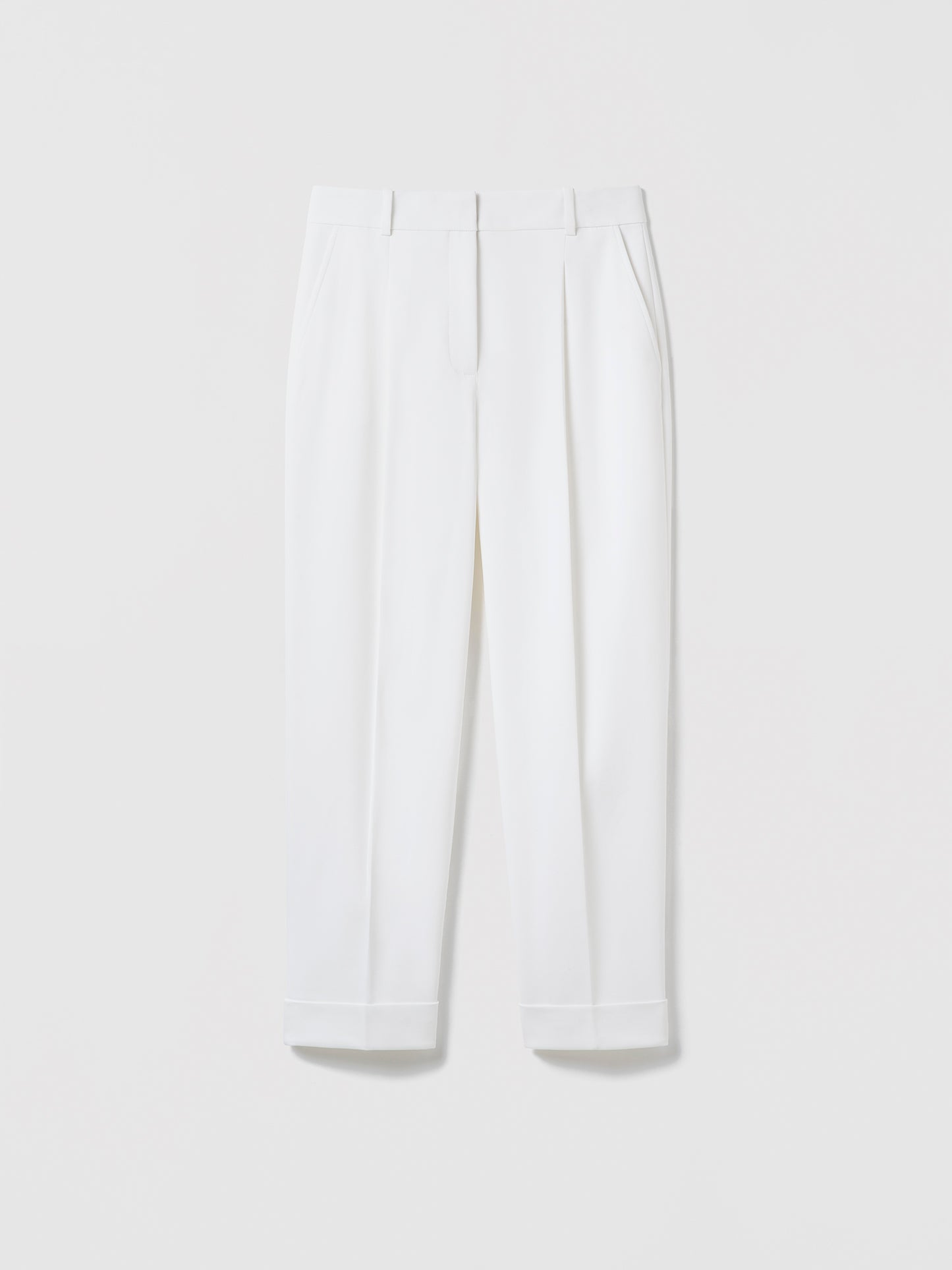 Flat‑lay of off‑white pleated cuffed trousers with slash pockets, welt pockets, and a clean tailored waistband.