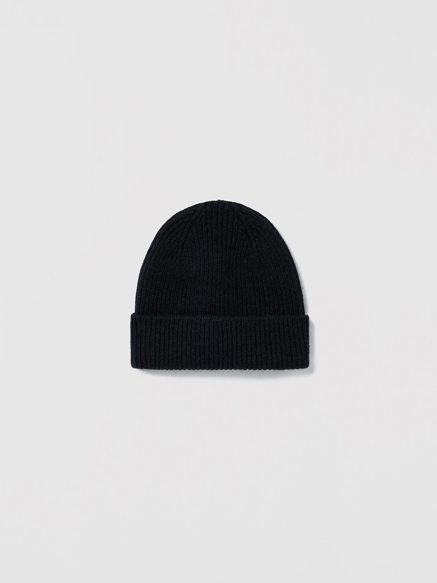 Flat lay of ribbed Le Bonnet black beanie in soft lambswool and Caregora blend, classic silhouette in wool knit, made in Scotland
