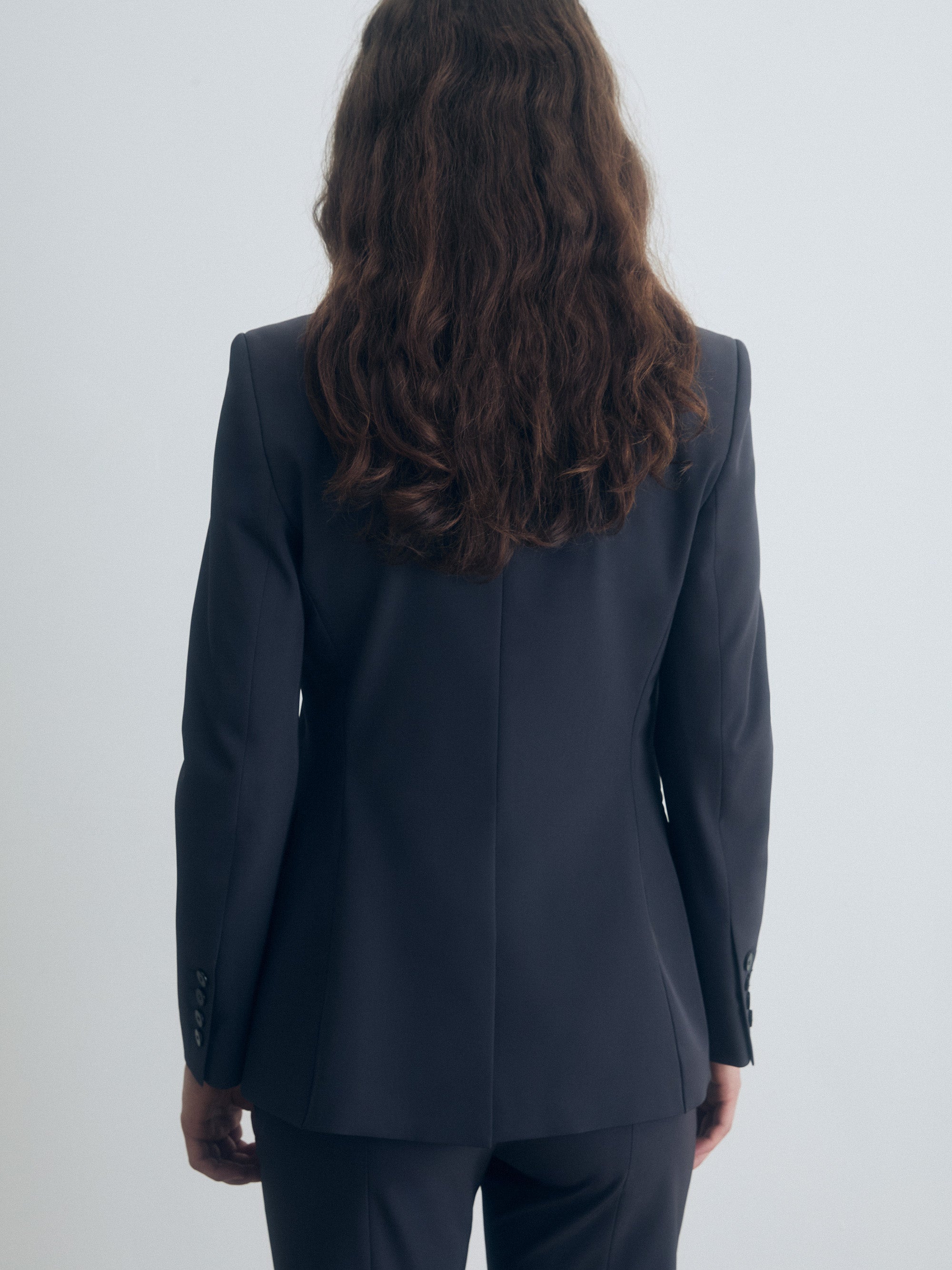 Person wearing a dark gray suit on a white background