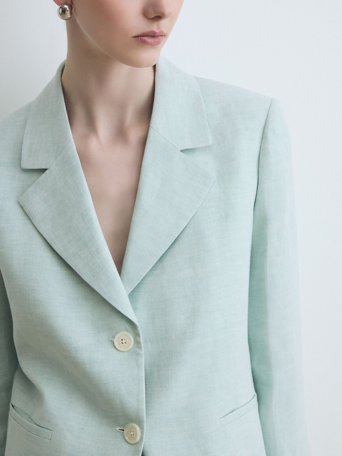 Light green blazer worn by a person on a light gray background