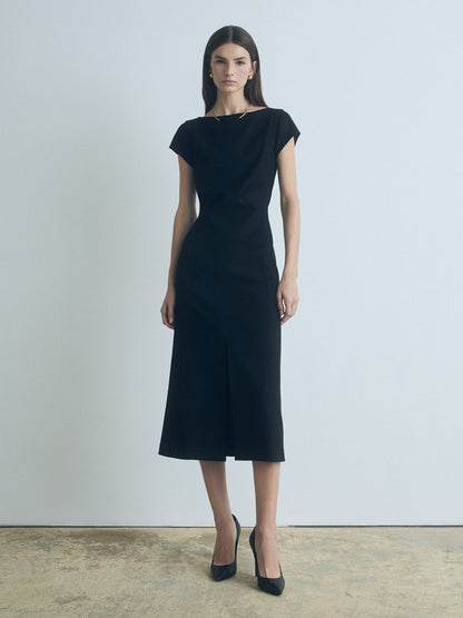 Model wearing a black wool-blend boat neck dress with front slit and invisible back zipper, fully lined, made in Canada from Italian fabric by Judith & Charles.
