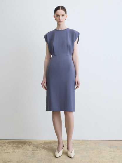 Woman wearing a sleeveless purple dress against a plain background