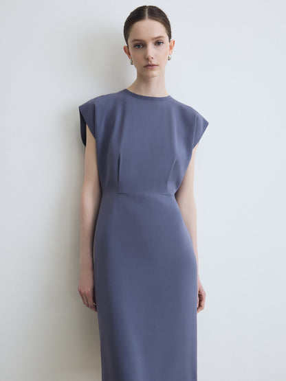 Woman wearing a sleeveless purple dress against a white background