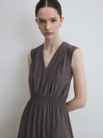 Woman wearing a grey dress against a plain background