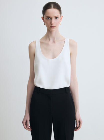 Sleeveless white silk top paired with a black pants