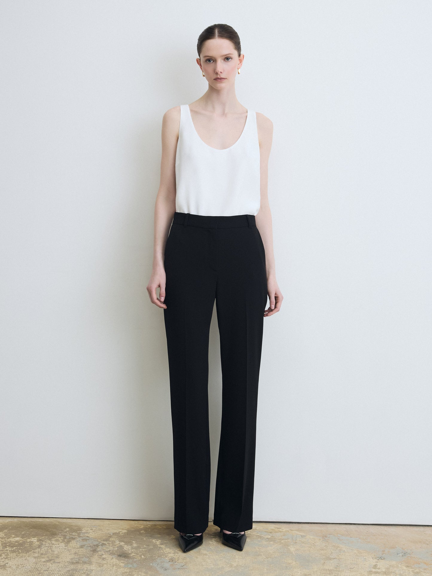 Sleeveless white silk top paired with a black pants