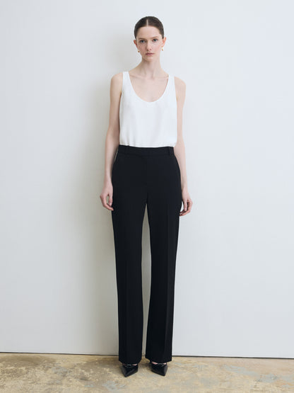 Sleeveless white silk top paired with a black pants