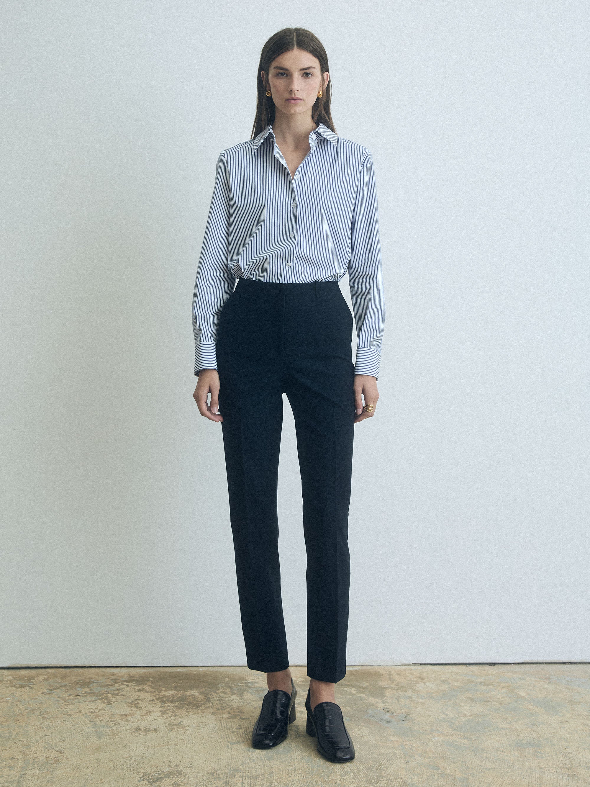 Person wearing a striped shirt and navy pants by judith and charles against a plain background