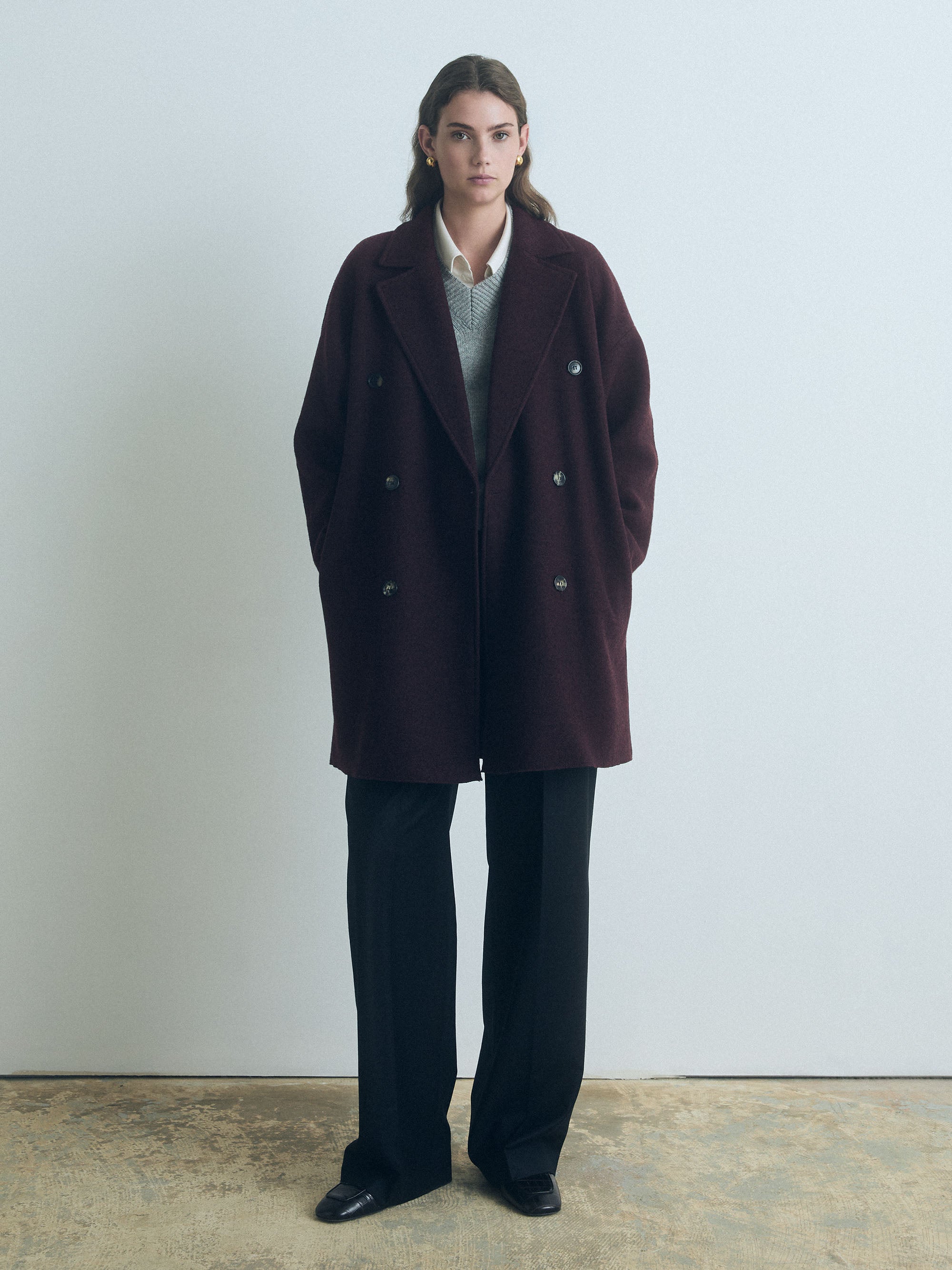 Woman wearing a Judith & Charles dark cherry double-breasted boiled wool coat, made in Canada.