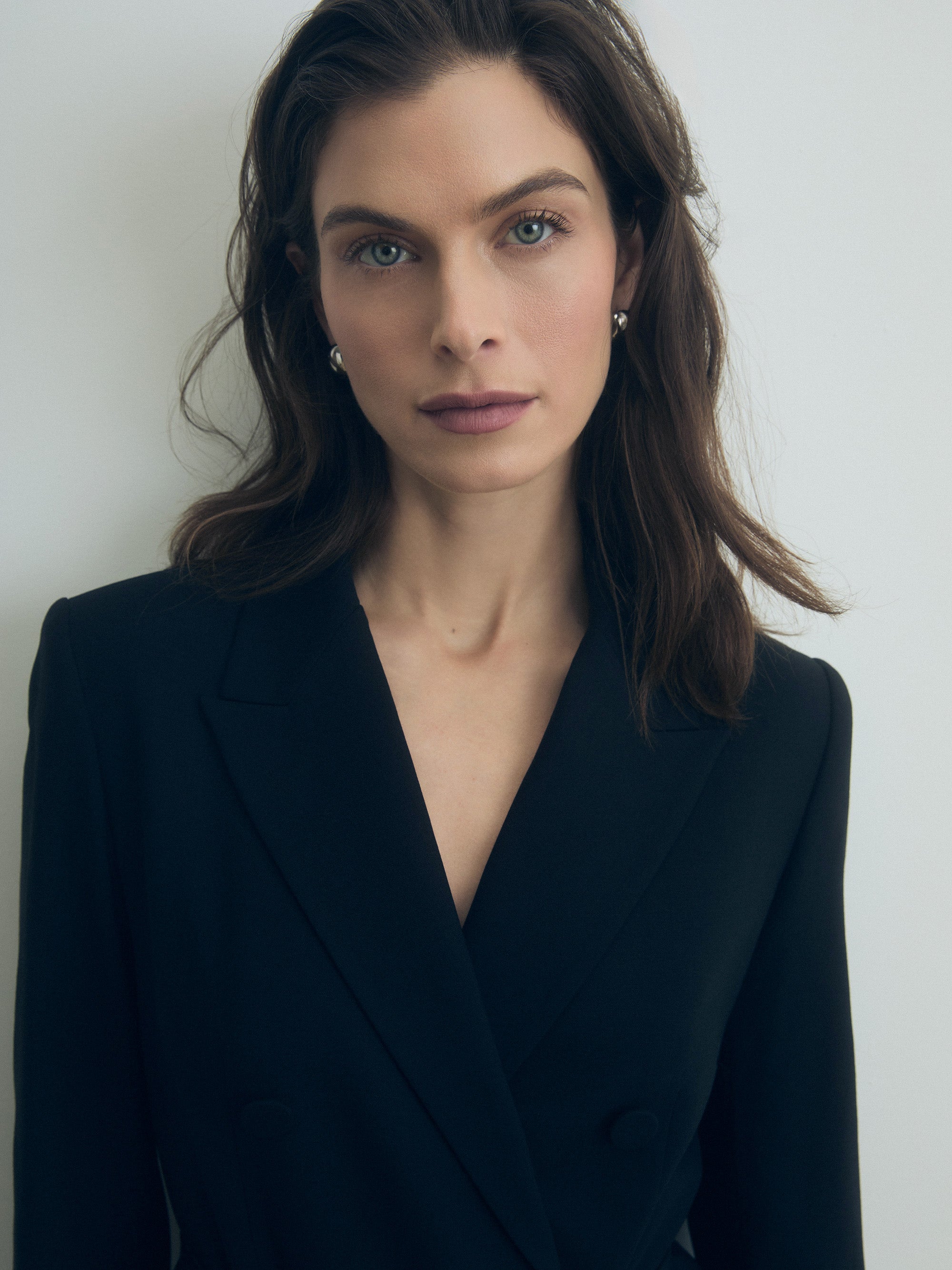 Woman wearing a black blazer dress against a plain background