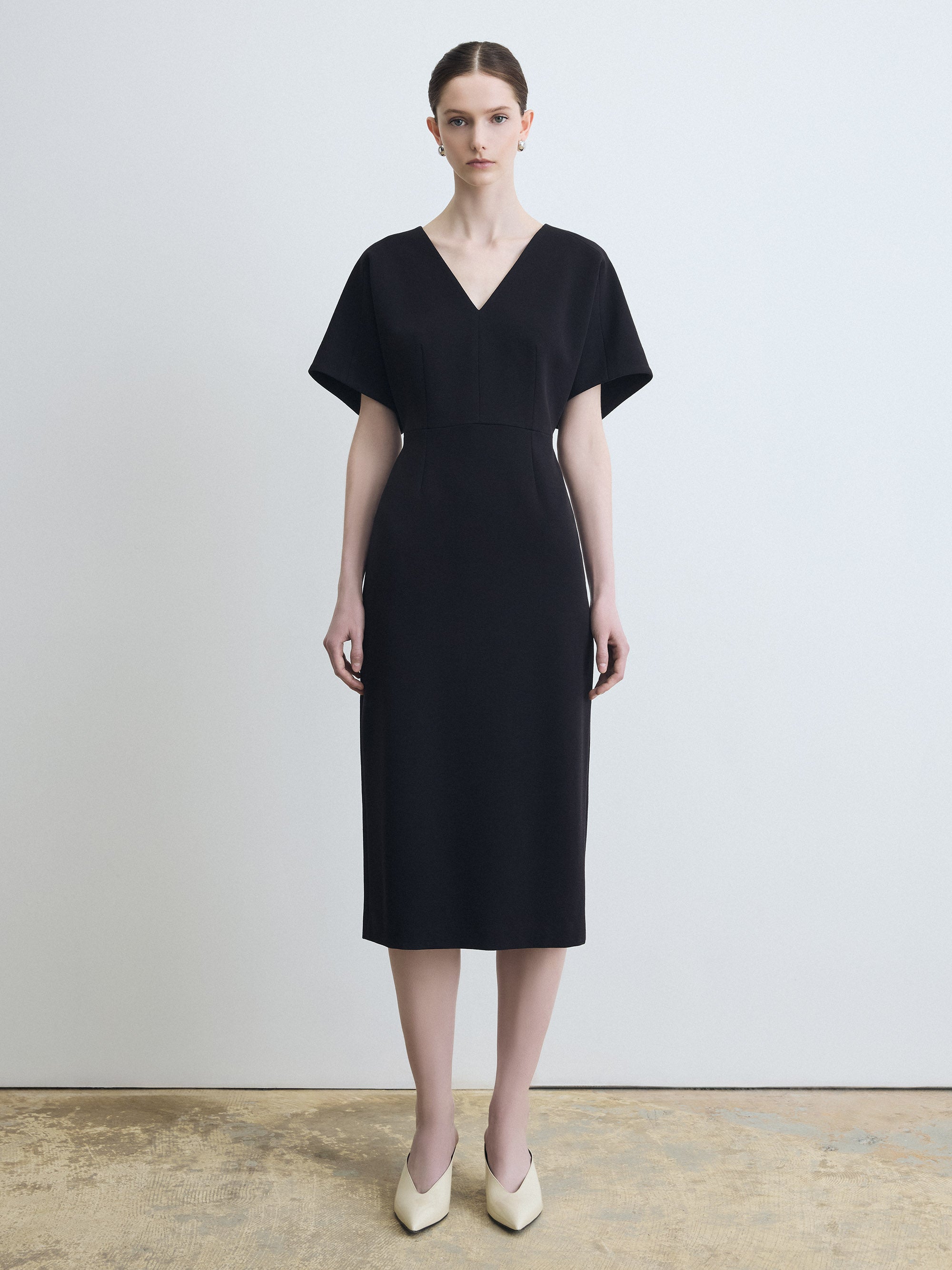 Woman wearing a black dress against a plain background