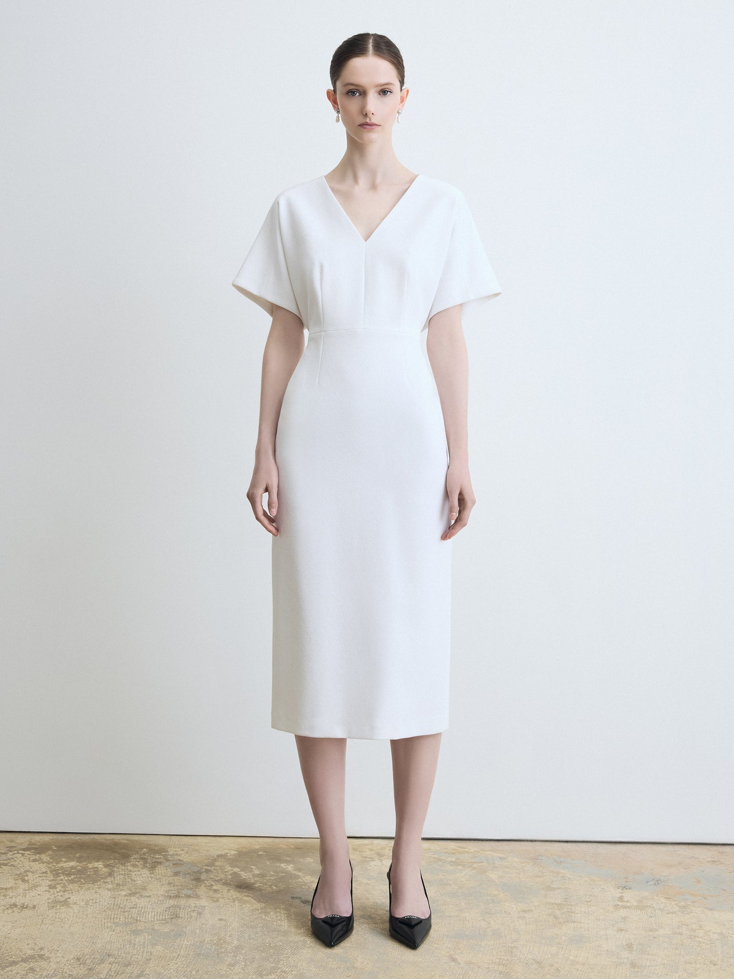 Woman wearing a white dress against a plain background