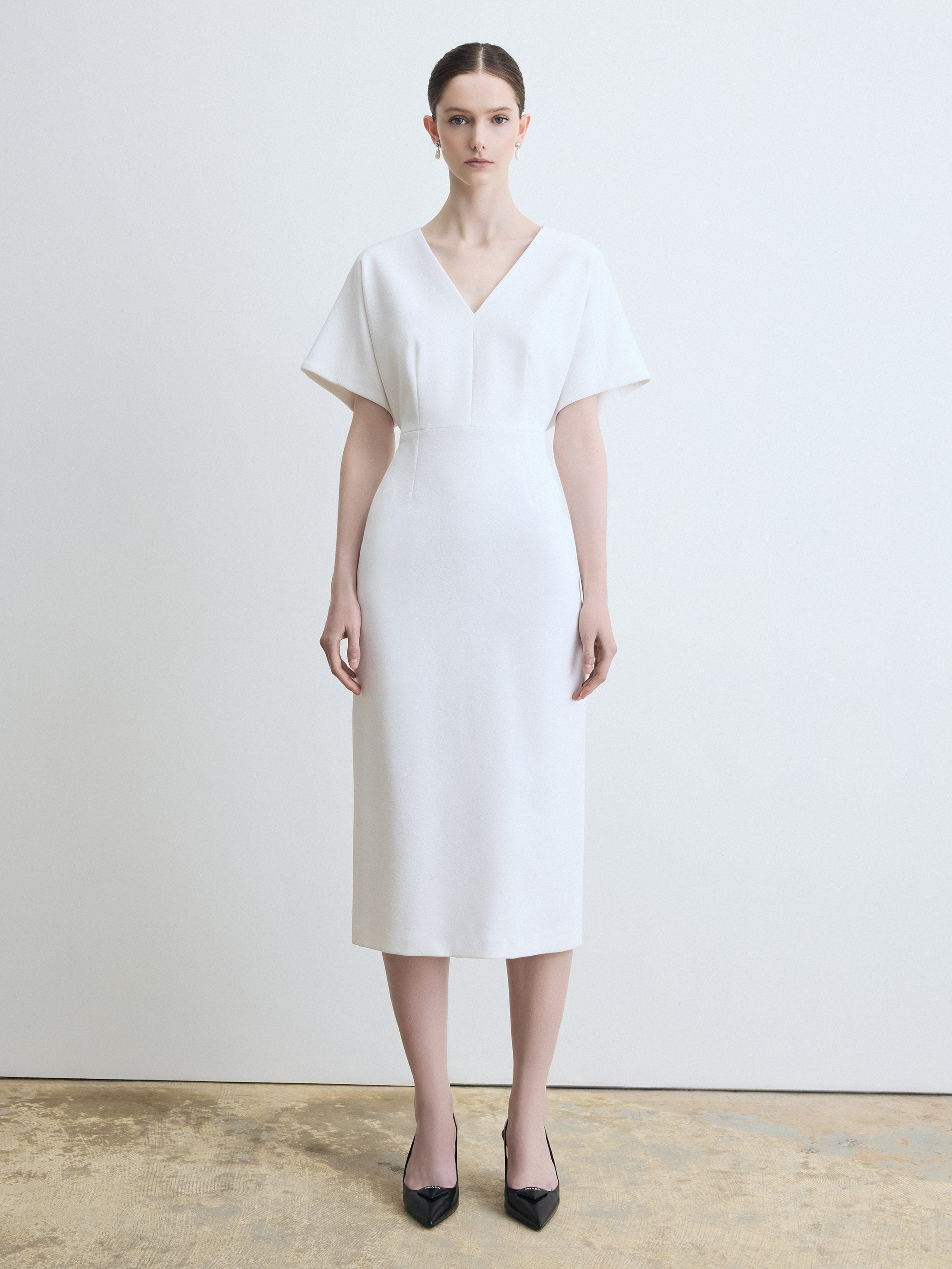 Woman wearing a white dress against a plain background