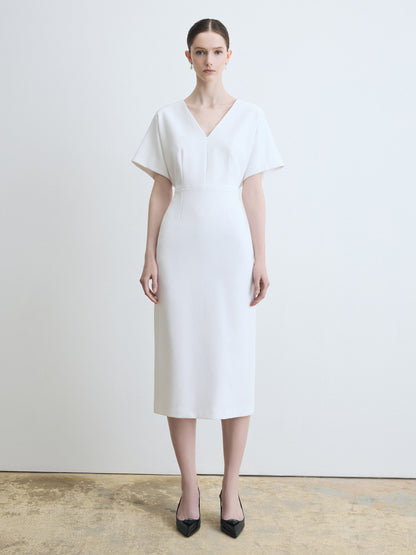 Woman wearing a white dress against a plain background