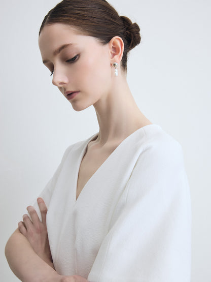 Woman wearing a white dress with a plain background