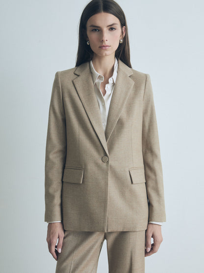 Model wearing Tailored Senna jacket in Camel Melange wool-cashmere blend with notch lapel, flap pockets, single back vent, fully lined, 96% wool, 3% cashmere, 1% elastane, made in Canada, by Judith and Charles. 