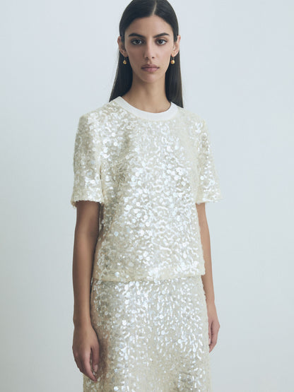Model wearing an Oyster white sequin top and skirt against a plain background