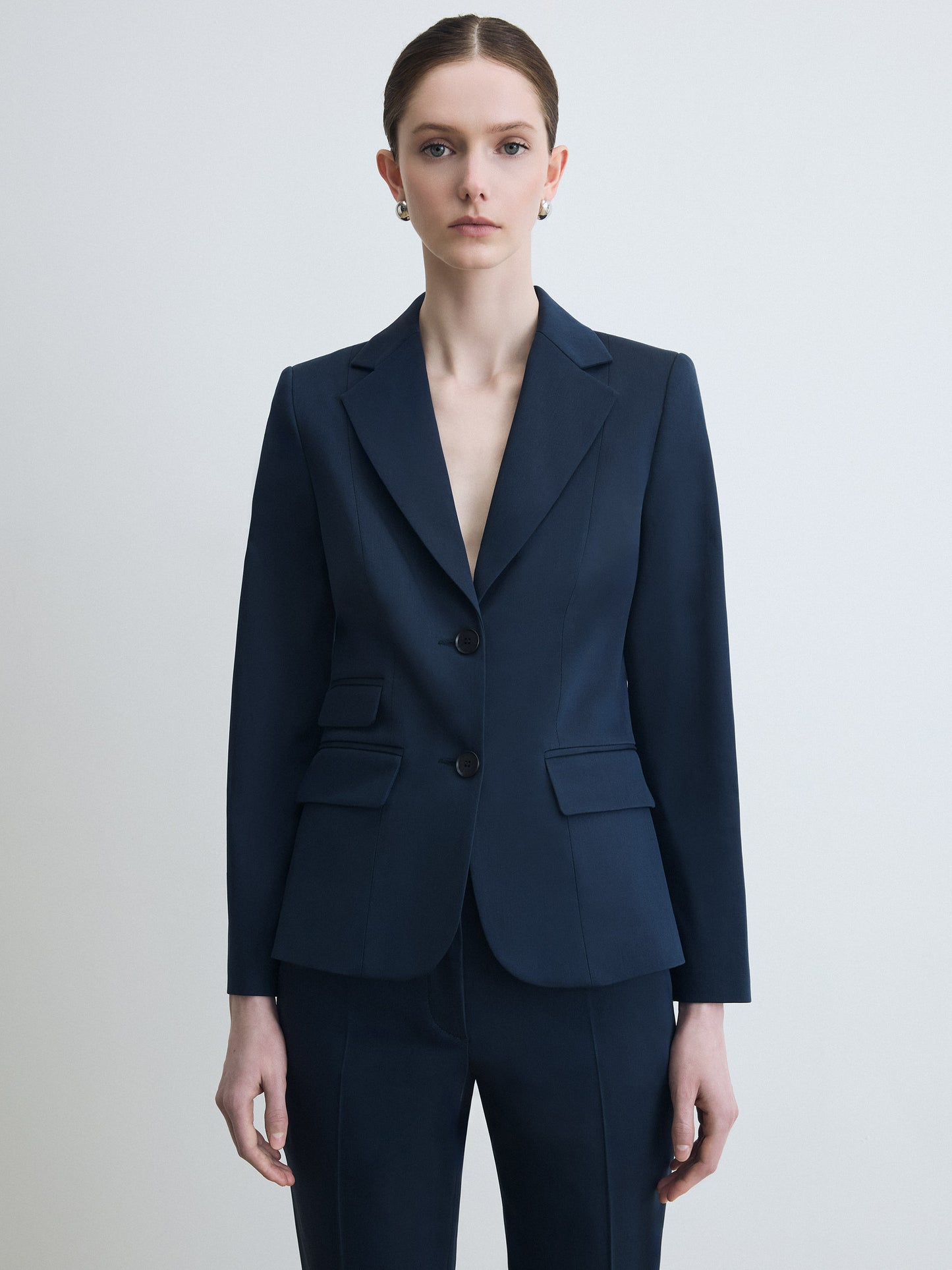 Navy blue suit worn by a model on a light gray background