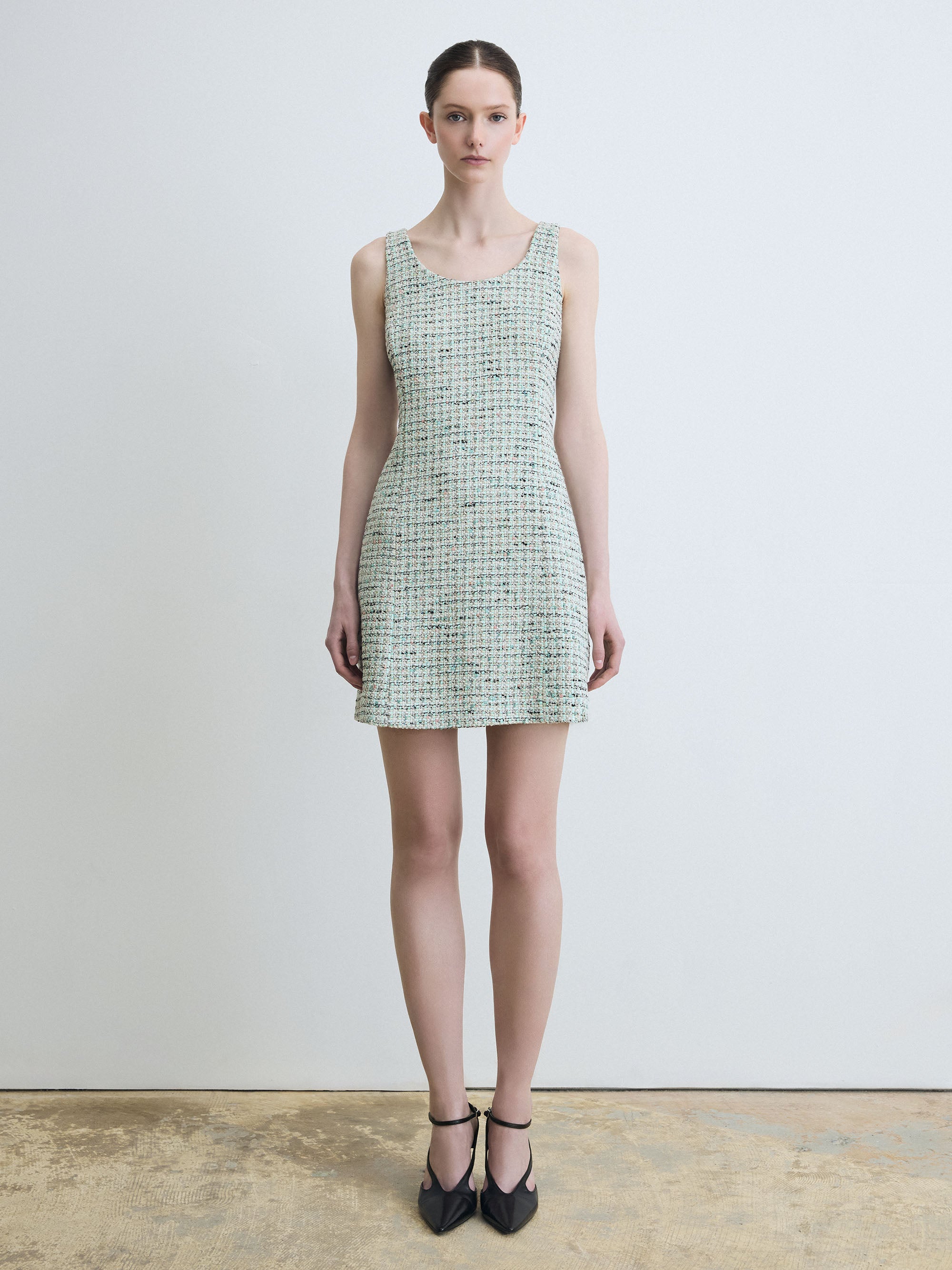 Woman wearing a green checkered dress against a white background
