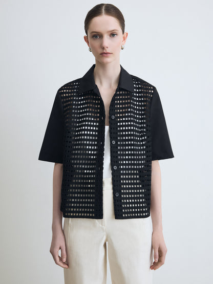 Person wearing a black perforated jacket on a white background