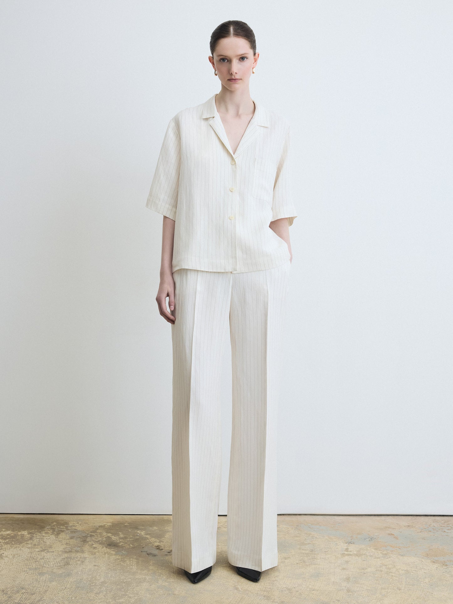 Person wearing a white outfit with a plain background