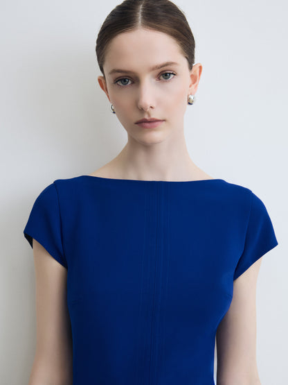 Woman wearing a blue dress against a plain background