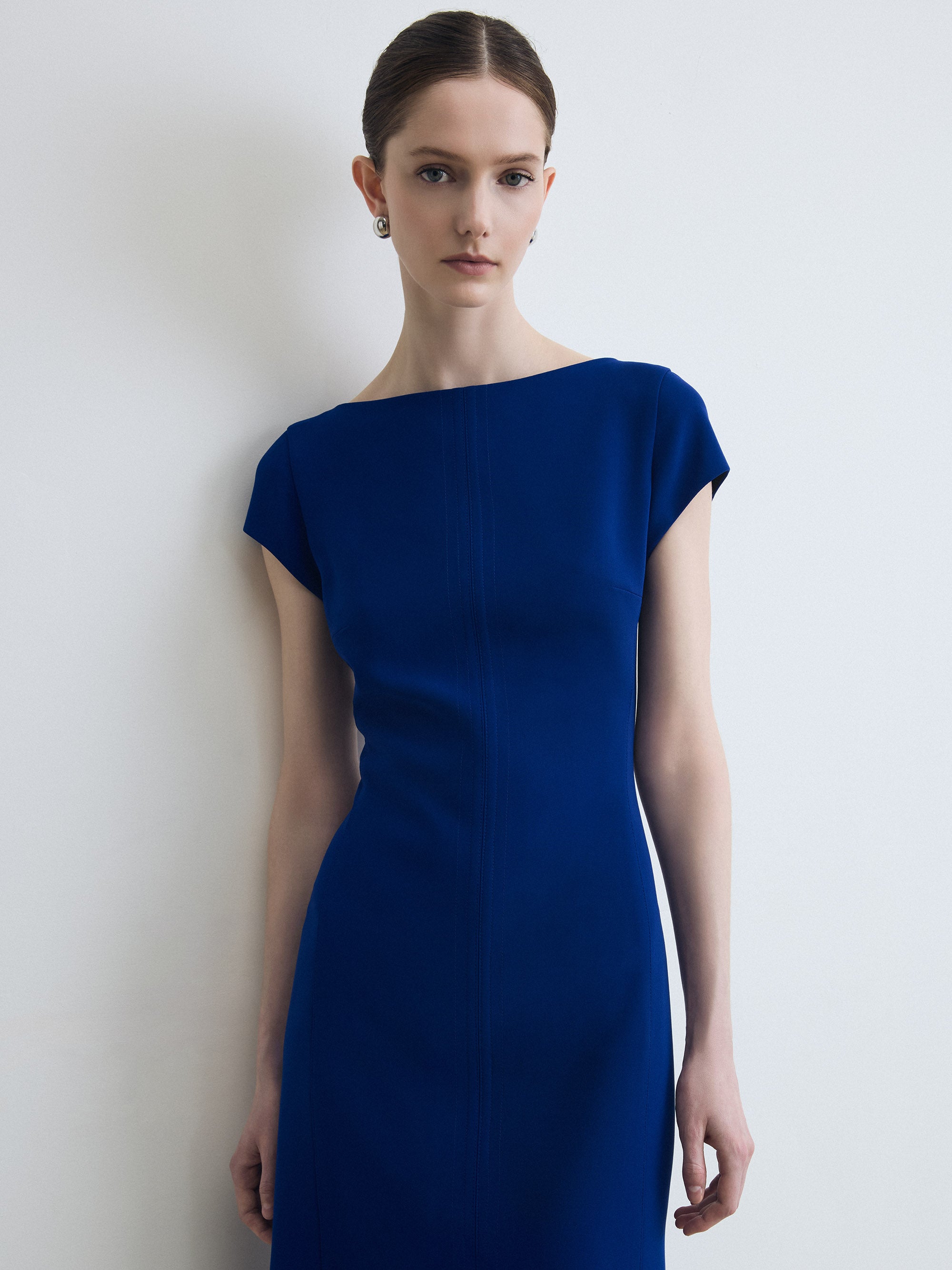 Woman wearing a blue dress against a white background