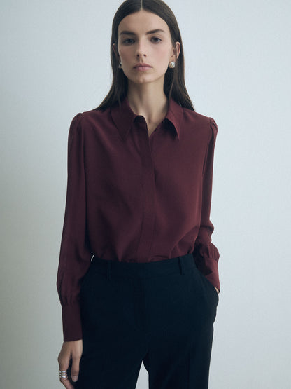Rust silk blouse from Judith & Charles with a classic collar and concealed button placket.