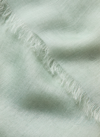 Close-up of light green fabric with frayed edges