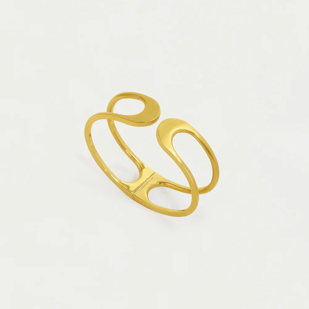 Gold cuff with a modern design on a light gray background