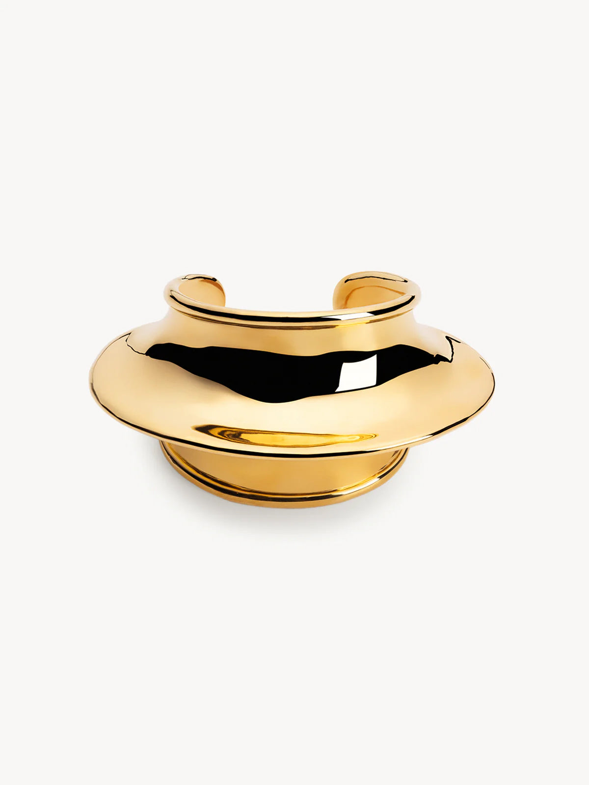 Gold cuff bracelet on a white background