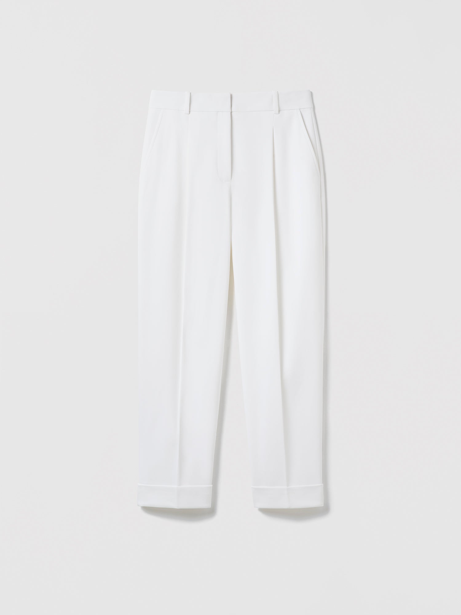 Flat‑lay of off‑white pleated cuffed trousers with slash pockets, welt pockets, and a clean tailored waistband.