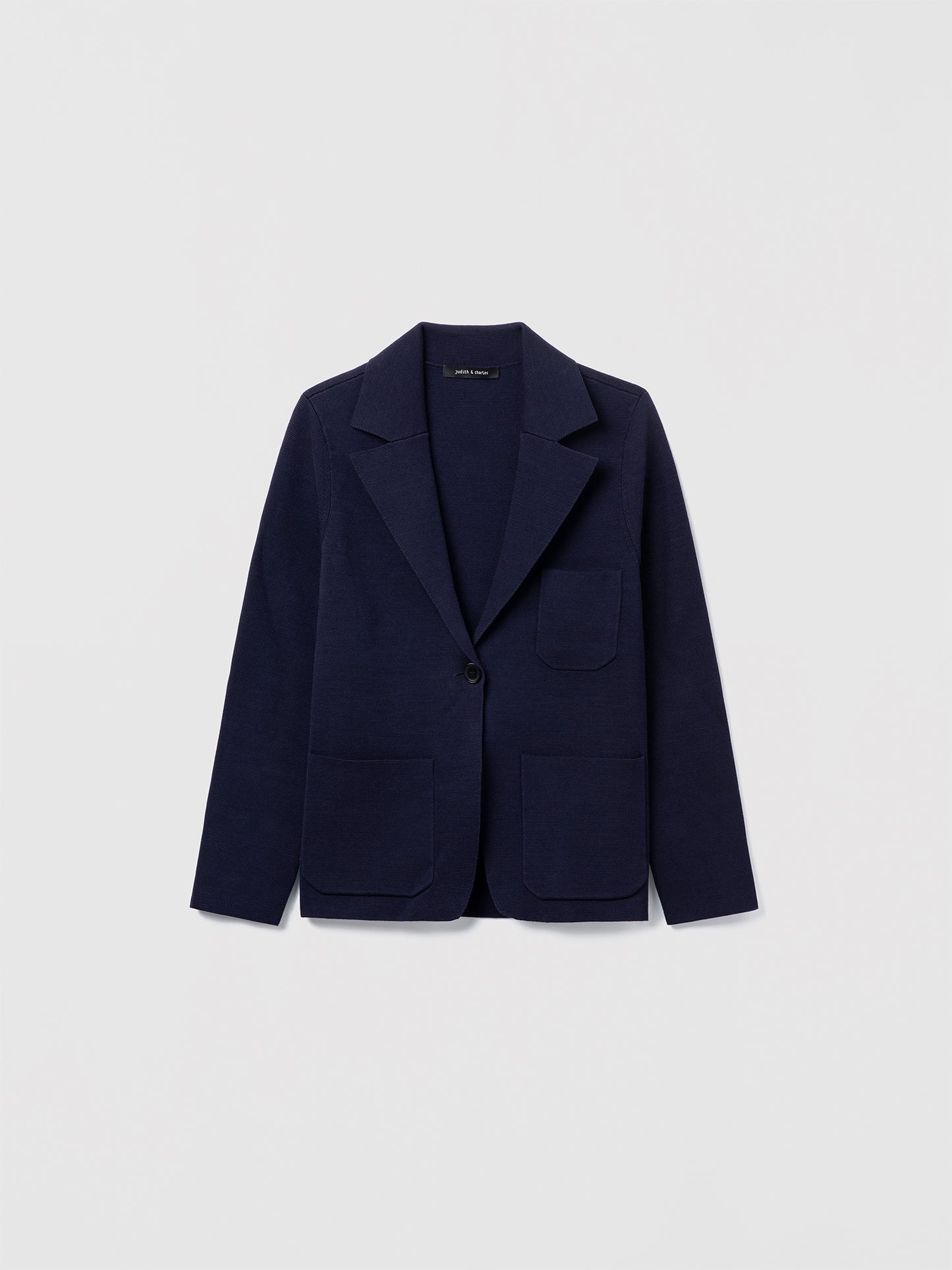 Judith and Charles navy Atticus Jacket – Semi-fitted, one-button knit jacket in 100% mercerized cotton with notch lapel, patch pockets, chest pocket, and 24.5″ back length; made from Italian fabric.