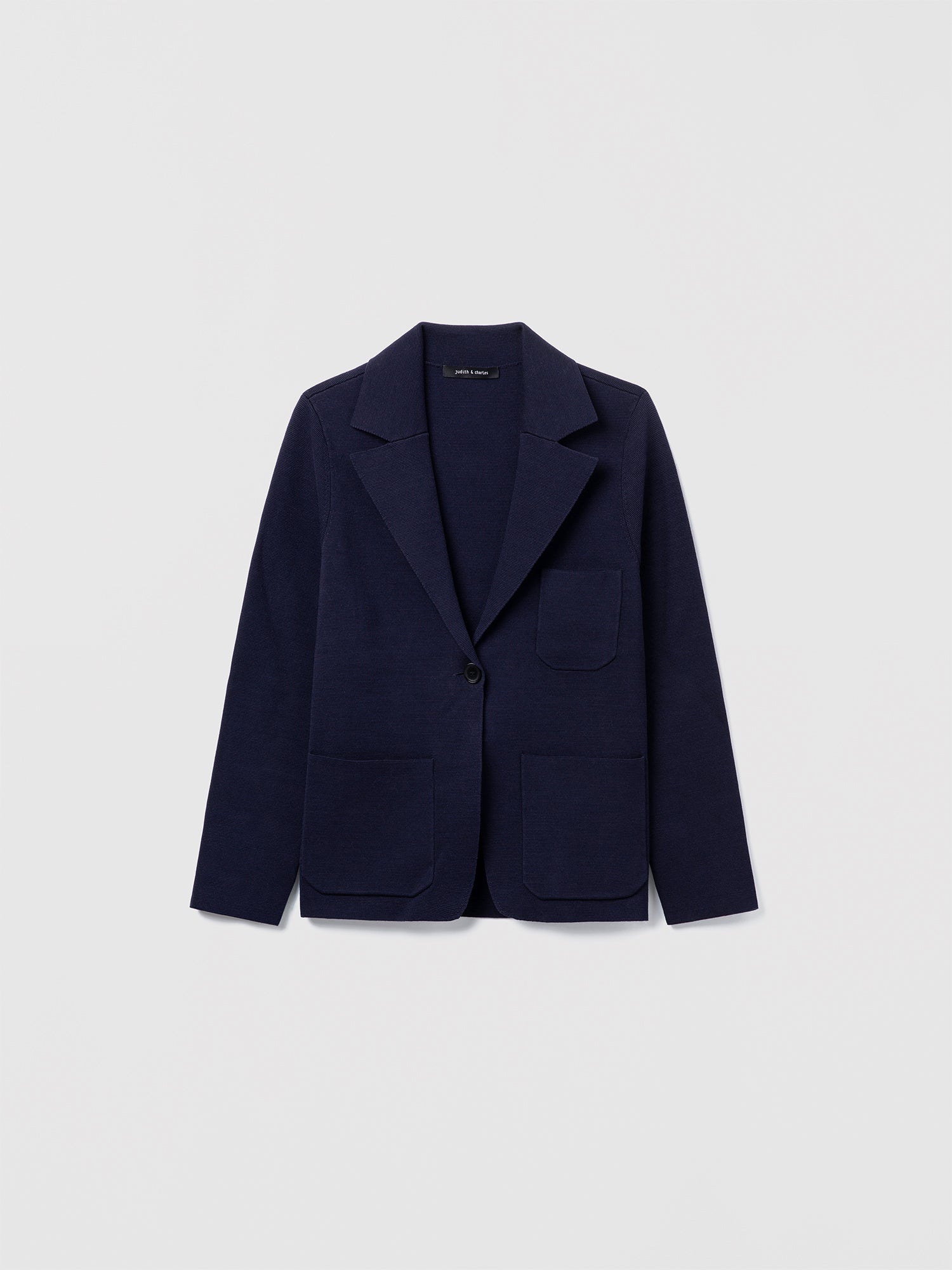 Judith and Charles navy Atticus Jacket – Semi-fitted, one-button knit jacket in 100% mercerized cotton with notch lapel, patch pockets, chest pocket, and 24.5″ back length; made from Italian fabric.