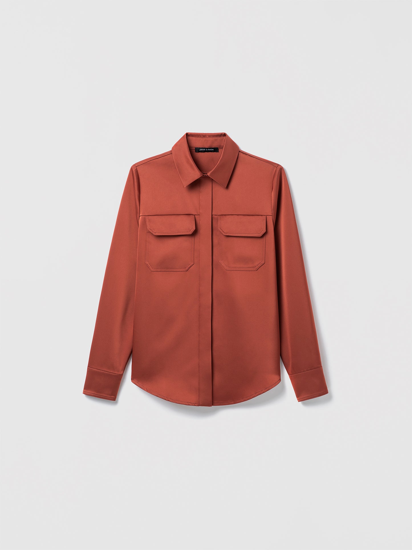 Terracotta long-sleeve button-up blouse with pointed collar and two front flap chest pockets, displayed flat against a white background.