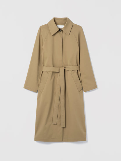 Long cotton trench coat with belt and welt pockets, shown in a clean, structured silhouette.