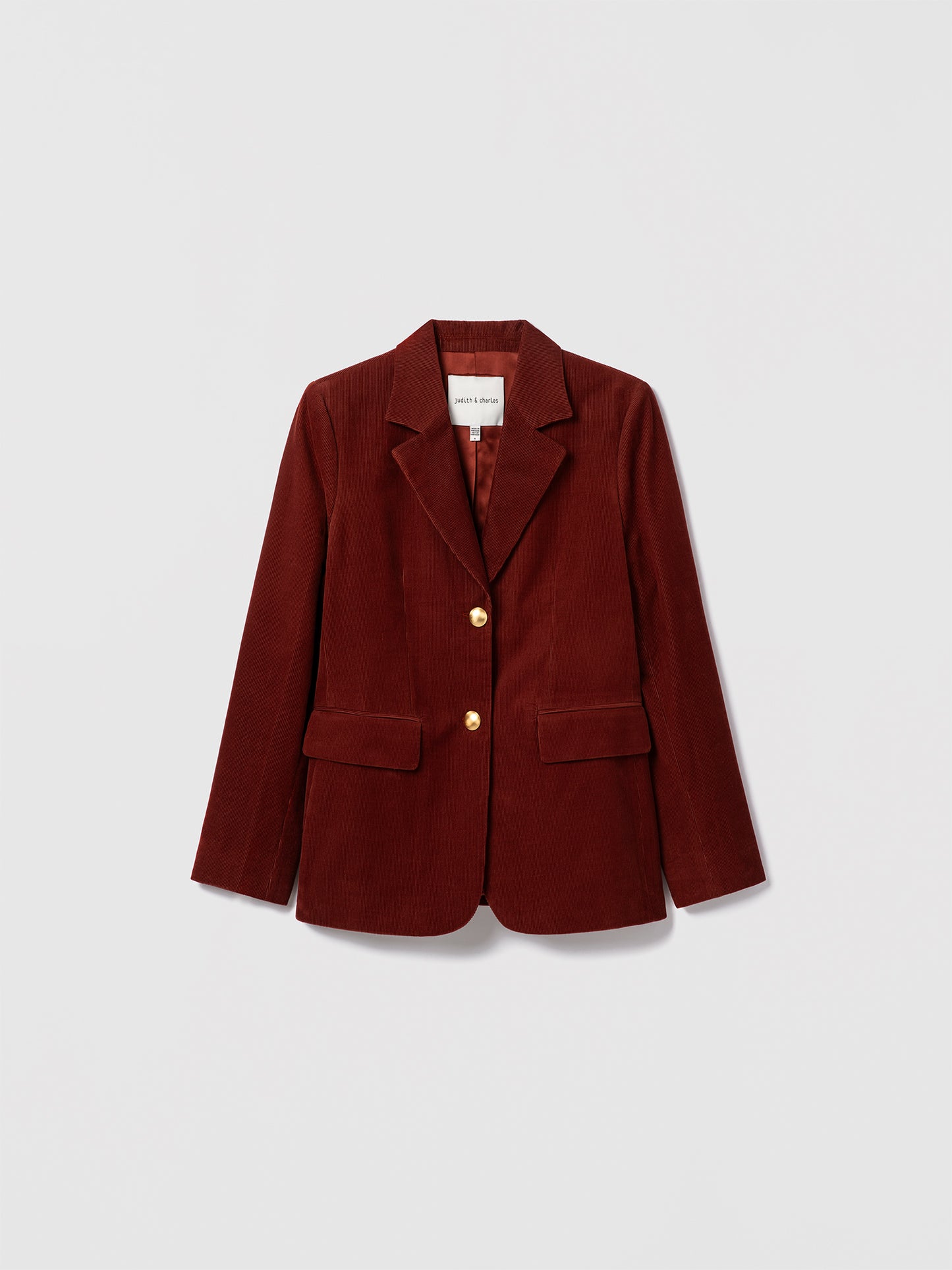 Judith & Charles rust stretch corduroy jacket with notch lapel, gold button closure, front flap pockets, and sleeve vents. Fully lined.