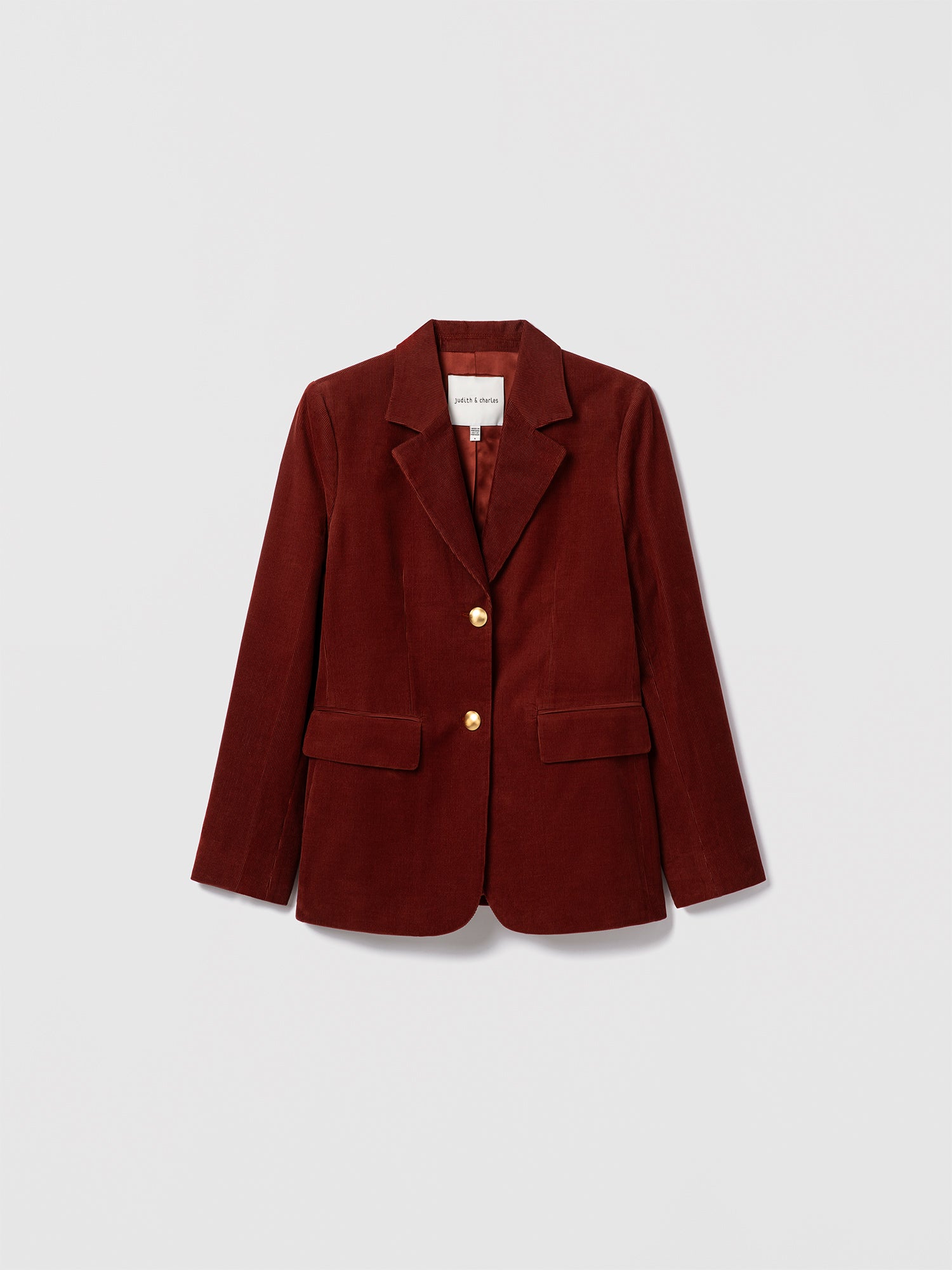 Judith & Charles rust stretch corduroy jacket with notch lapel, gold button closure, front flap pockets, and sleeve vents. Fully lined.