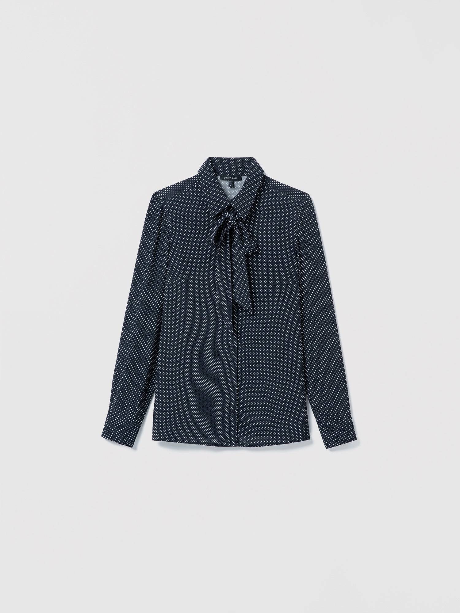 Navy off white patterned blouse with a tie detail on a light gray background