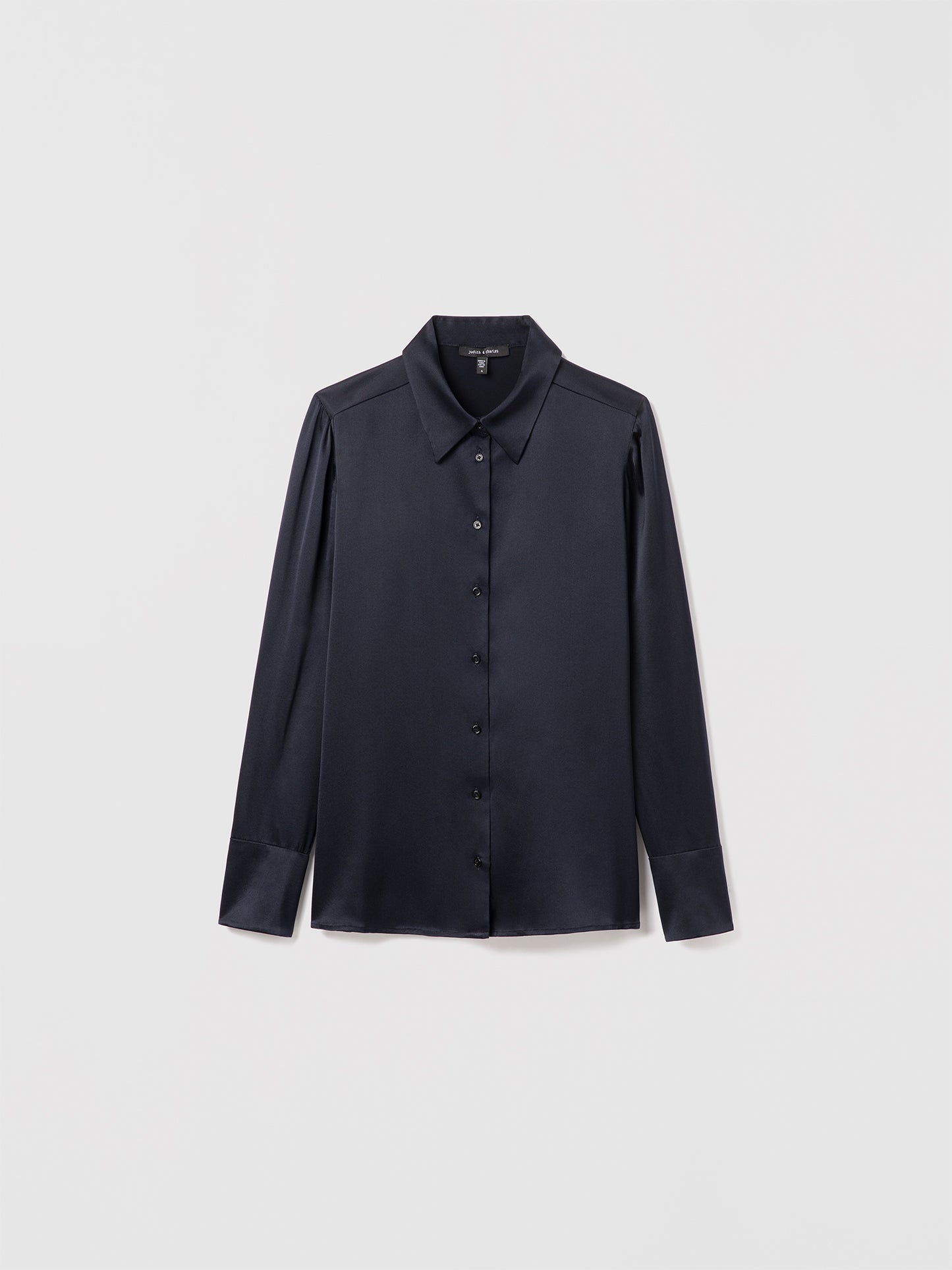 Navy satin silk blouse by Judith & Charles featuring long sleeves, a shirt collar, and front button closure; semi-fitted silhouette, unlined, 25″ back length.