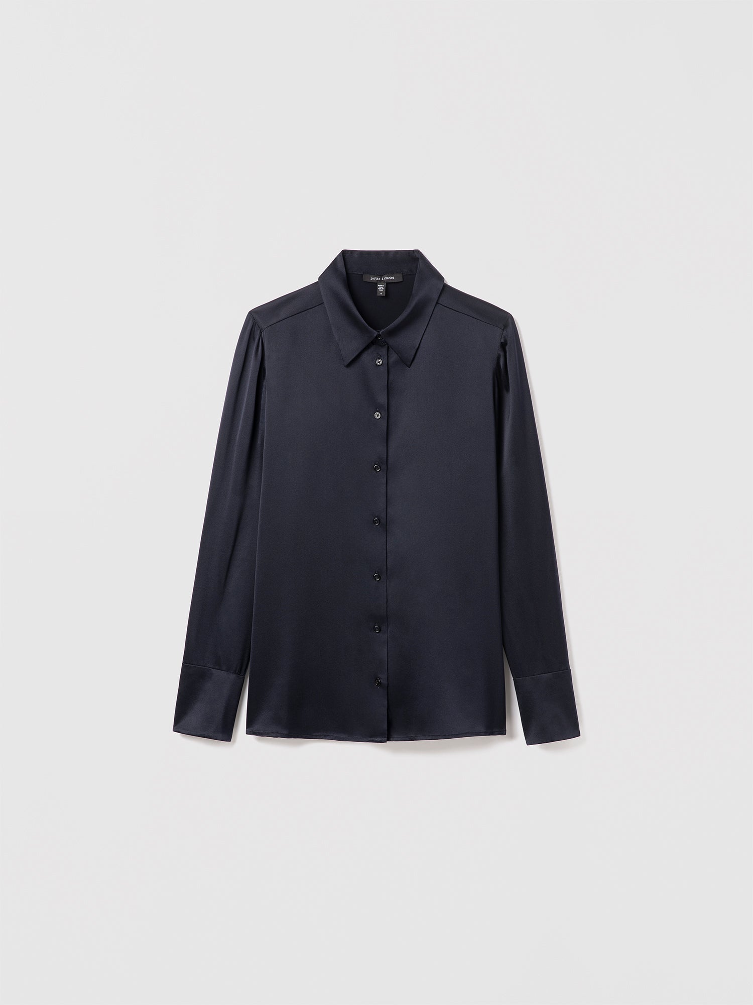 Navy satin silk blouse by Judith & Charles featuring long sleeves, a shirt collar, and front button closure; semi-fitted silhouette, unlined, 25″ back length.