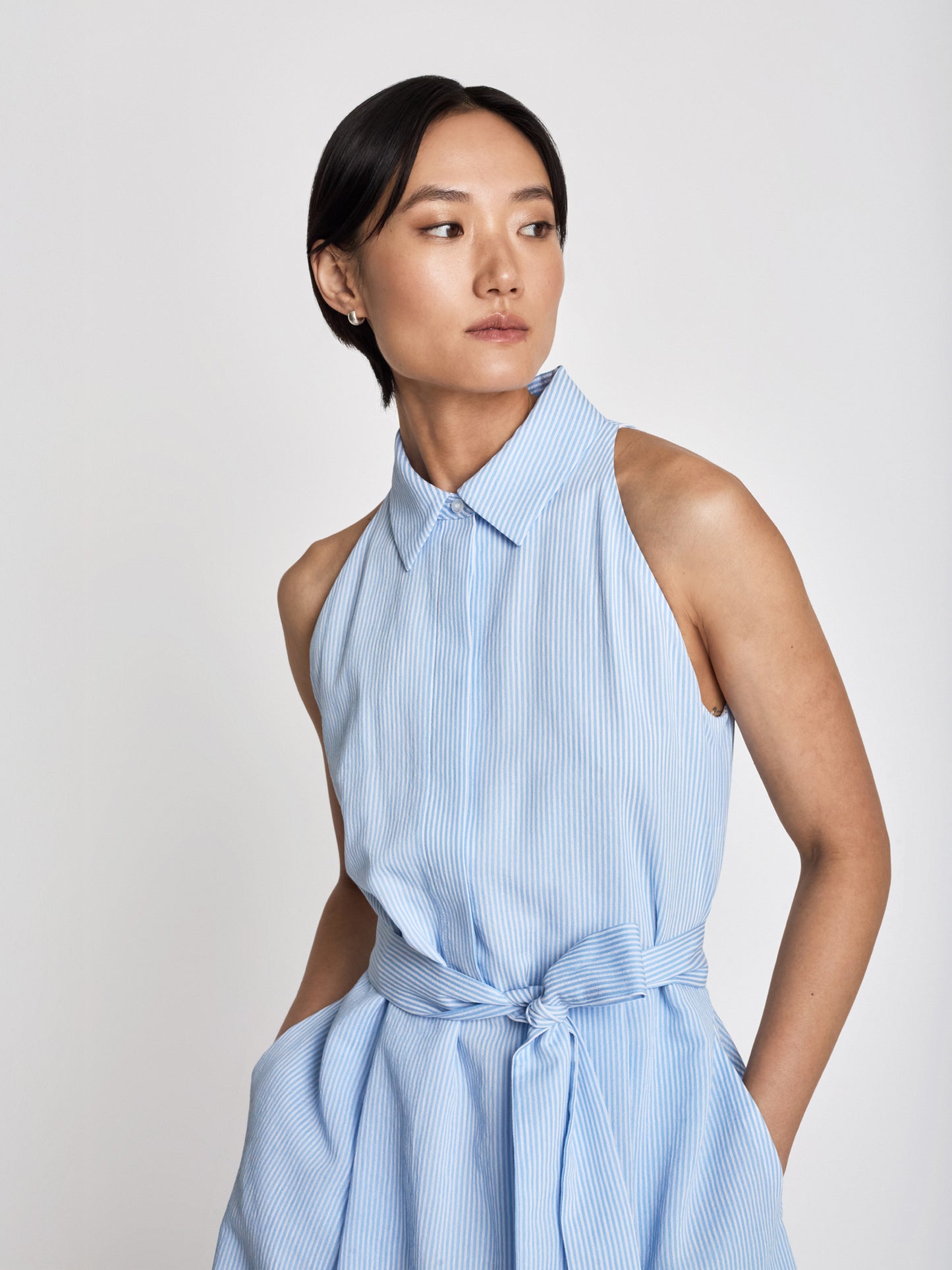 Judith and Charles blue Lucianne Dress – below-the-knee halter shirt dress in textured stripe fabric (55% viscose, 29% cotton, 16% polyamide) with an easy-fit silhouette; made in Canada from Italian fabric