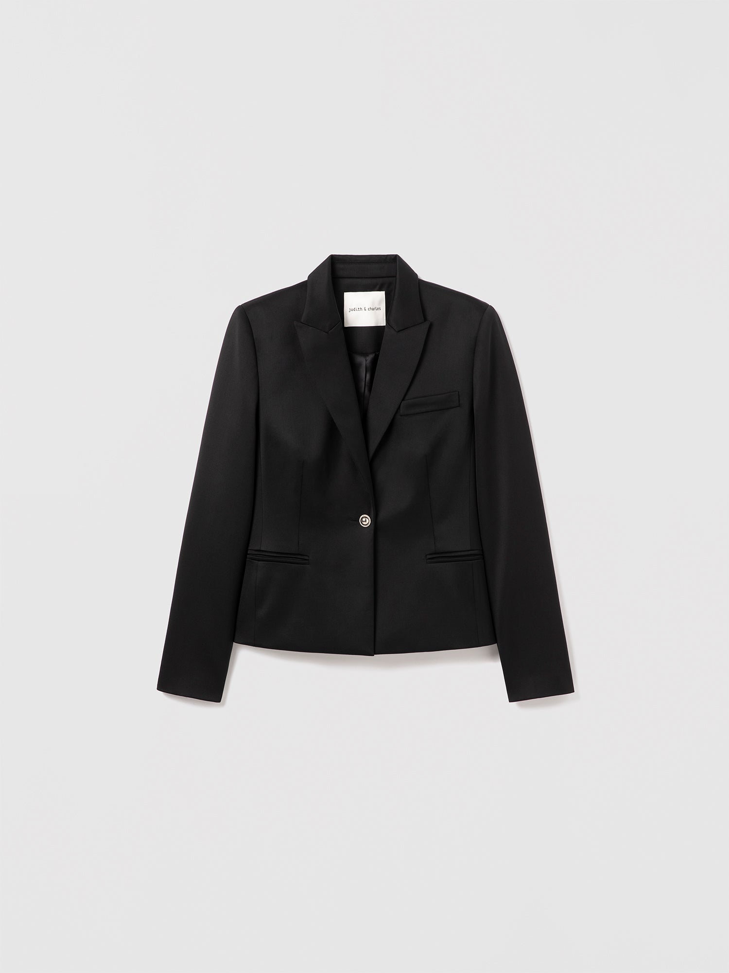Black tuxedo jacket by Judith and Charles with peak lapels and jewel button closure, made in Canada.