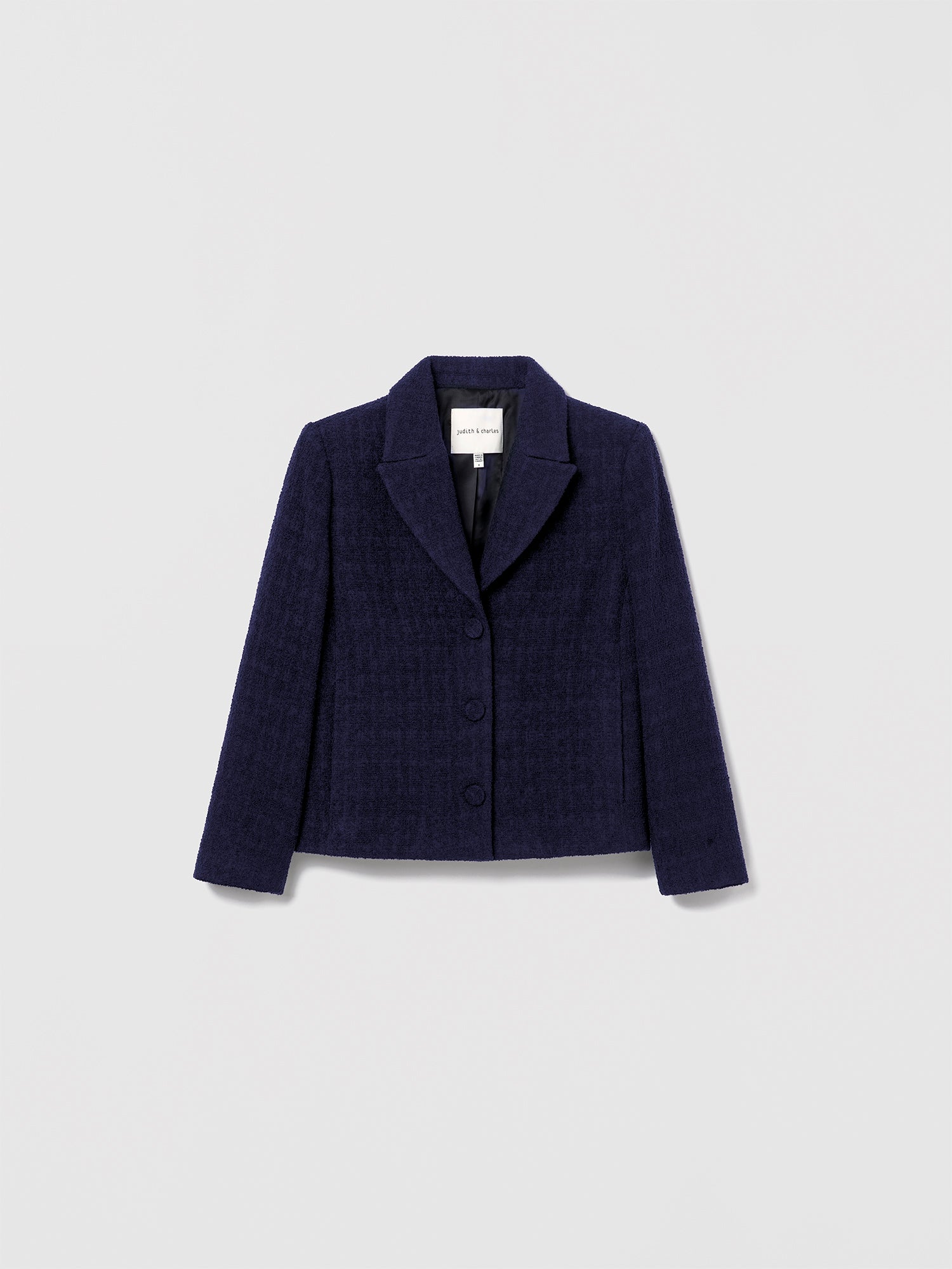 Navy boxy tailored jacket by Judith & Charles, with notch lapel, self-covered buttons, and seam pockets.