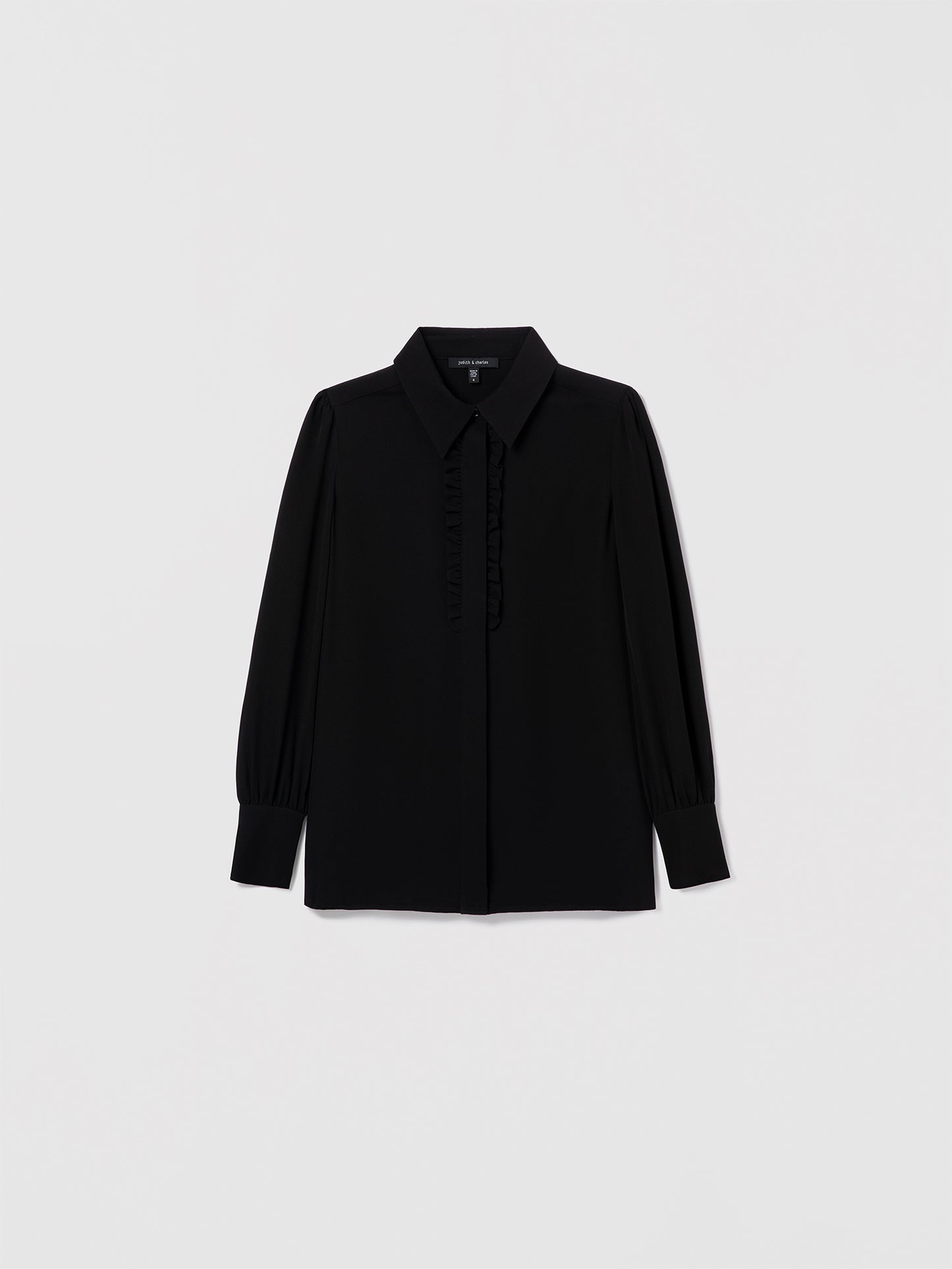 Black silk blouse by Judith & Charles featuring a shirt collar, hidden button placket, and double-layer ruffle detail at the front.