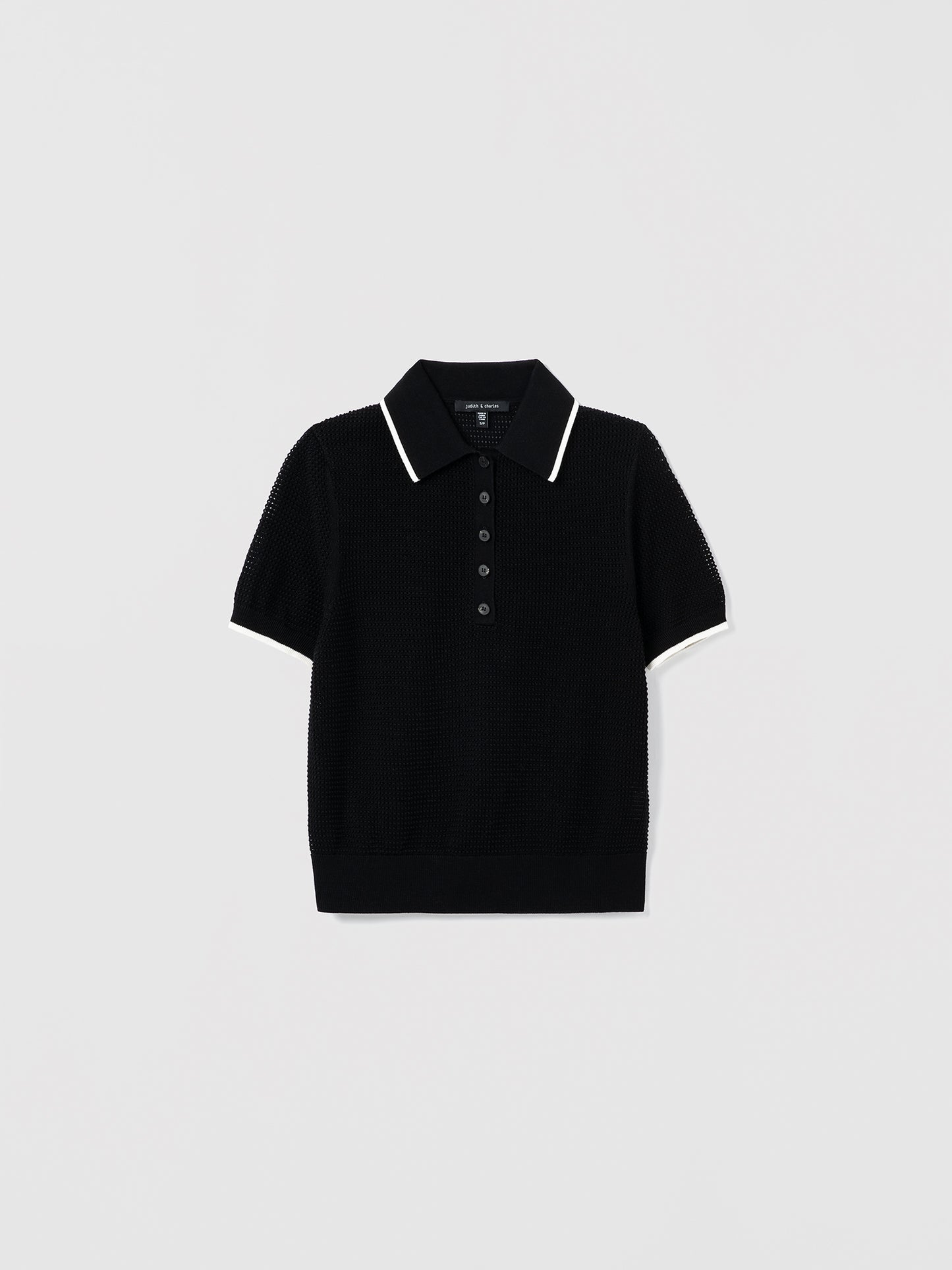 Black and off white polo shirt with white trim on a light gray background