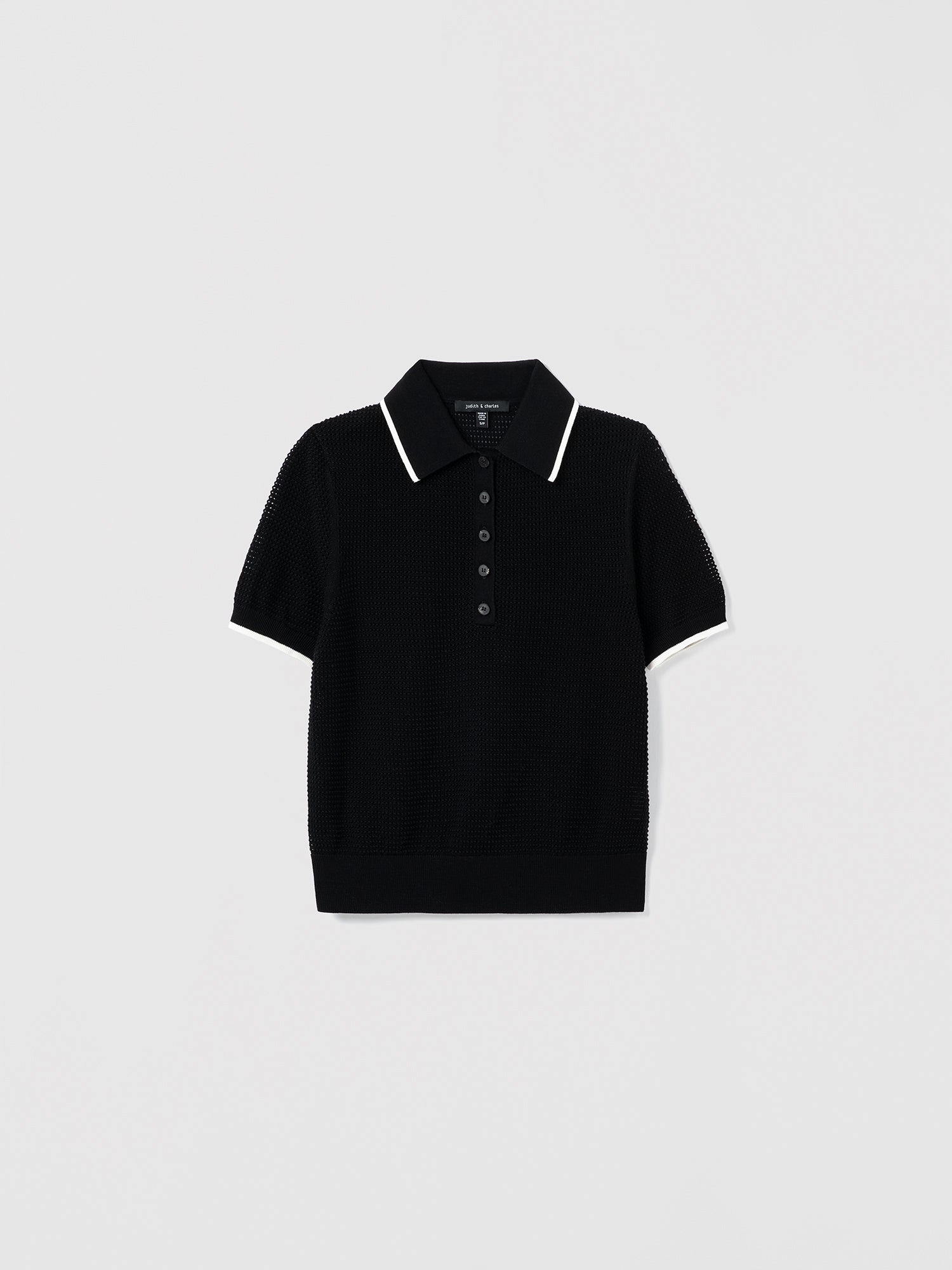 Black and off white polo shirt with white trim on a light gray background